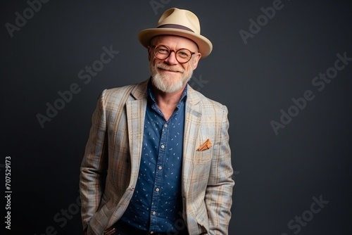 Portrait of a happy senior man in hat and glasses. Studio shot. © Inigo