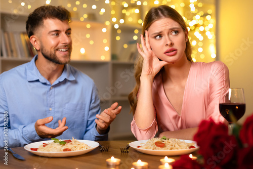 Fotografie Man talking earnestly, woman annoyed at romantic dinner