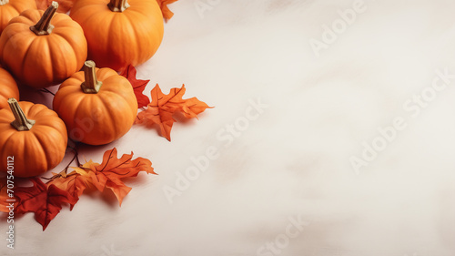 Fall background with orange pumpkins and fall leaves on a light surface