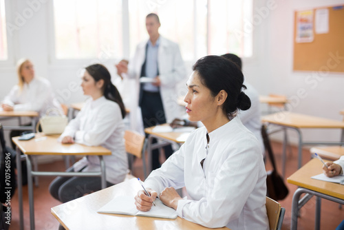 Portrait of confident asian female doctor listening lectures within refresher course. Professional development concept photo