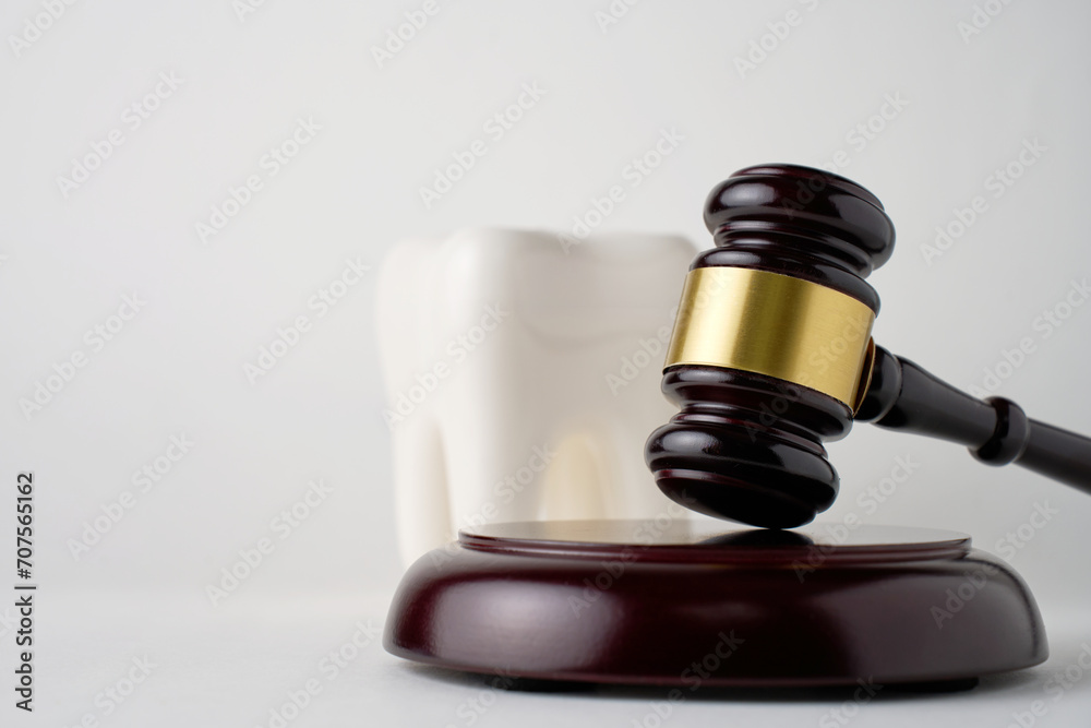 Dental insurance concept. White tooth and judge gavel Dental insurance concept. White tooth and judge gavel
