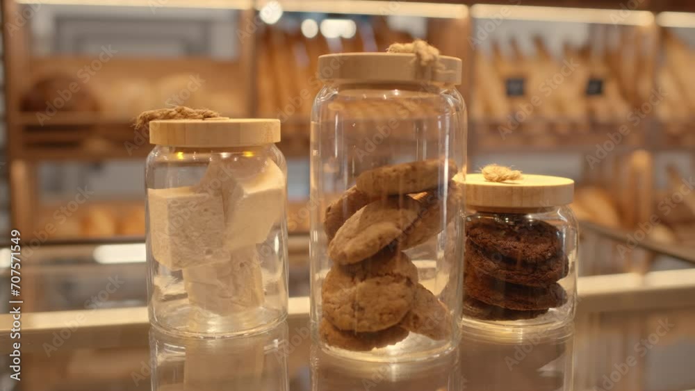 No people shot of delicious confectionary assortment including oatmeal cookies and marshmallows in three jars on glass display for sale at bakery No people shot of delicious confectionary assortment including oatmeal cookies and marshmallows in three jars on glass display for sale at bakery