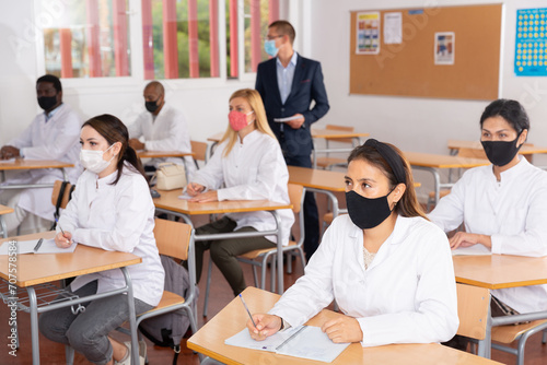 Focused adult medical students different nationalities wearing protective face masks to prevent viral infections attending refresher course. New life reality in coronavirus pandemic