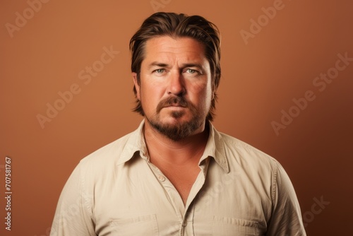 Portrait of a handsome man over brown background. Men's beauty, fashion. © Inigo
