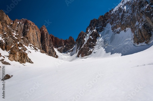Mountaineers difficult alpine climbing up steep icy cliffs. Expedition ascends with great risk to steep peak. Snowy glacier, high mountains. Alpine, hiking, climbing. Extreme ascent of strong people