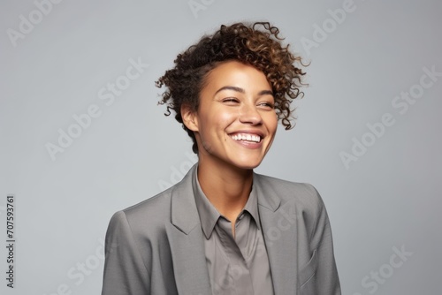 happy african american businesswoman with curly hair over grey background © Inigo