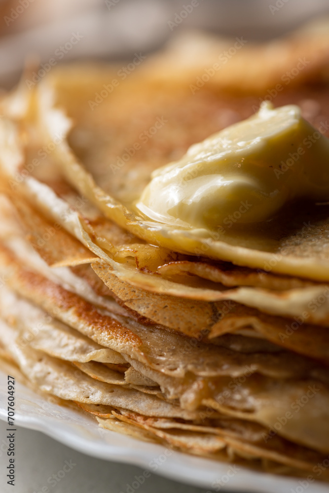 A stack of pancakes with a piece of melted butter A stack of pancakes with a piece of melted butter