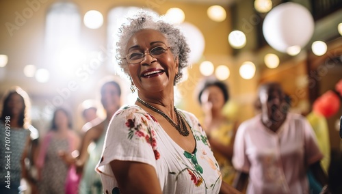Elderly African American woman with short gray hair smiling against a backdrop of dancing people