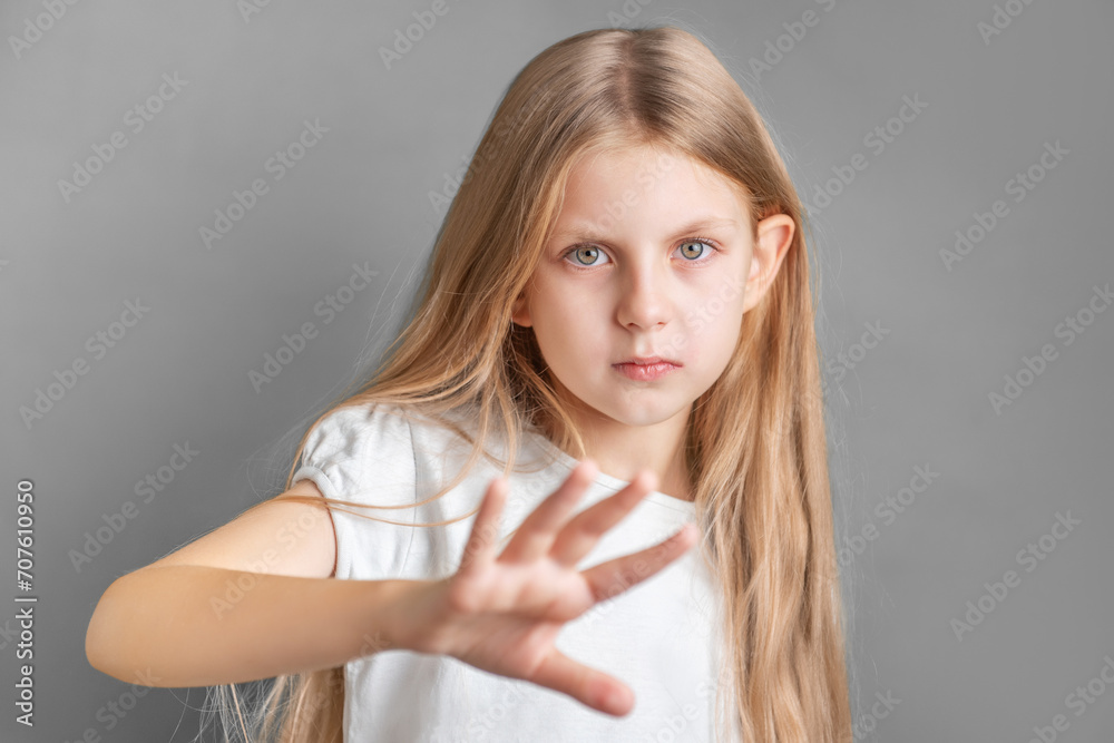 Fototapeta premium A little girl showing a sign of protest or refusal with her hand.