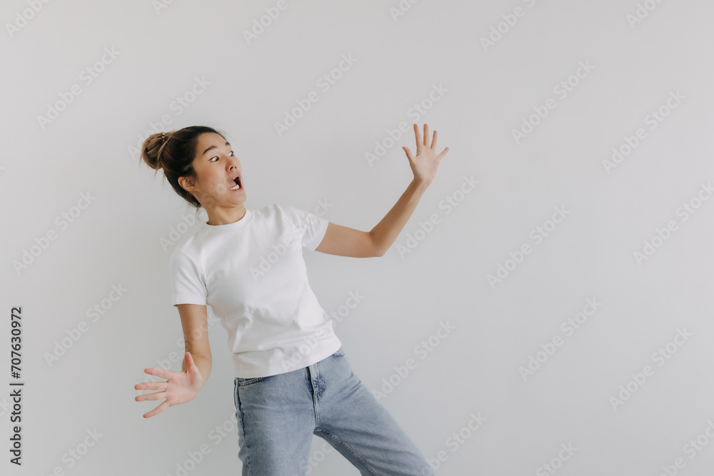 Asian Thai woman spreading arms and legs wide with funny surprised, wow, shocked face, crazy standing isolated over white background wall. Asian Thai woman spreading arms and legs wide with funny surprised, wow, shocked face, crazy standing isolated over white background wall.