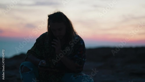 Young Male at sunset sitting down on his phone slow motion holiday photo