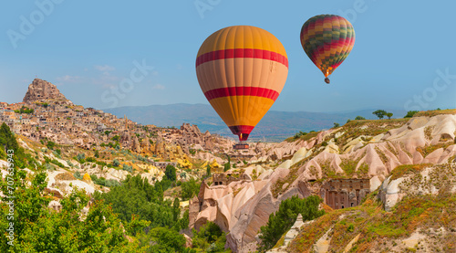 Hot air balloon flying over spectacular Cappadocia, Uchisar castle in the background - Goreme, Turkey © muratart