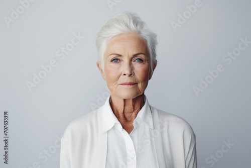 Portrait of senior woman looking at camera. Isolated on grey background