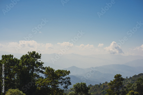 landscape and travel concept with solo freelancer man sit on wooden and use tablet work from outdoor with layer of mountain background