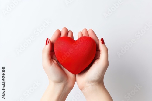Close-up of a woman holding a red heart in her hands. Top view. Valentine s Day Card.