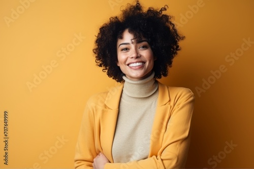 Portrait of a beautiful african american woman smiling at camera over yellow background © Inigo