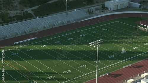 High school or college American football field - rising aerial tilt down photo