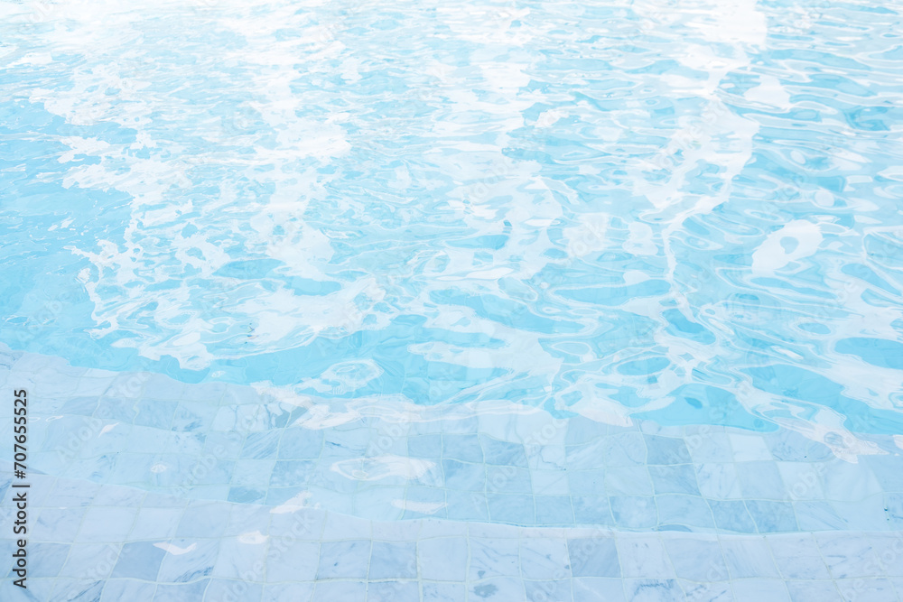 Swimming pool edge, close up background. Clear blue water in the pool