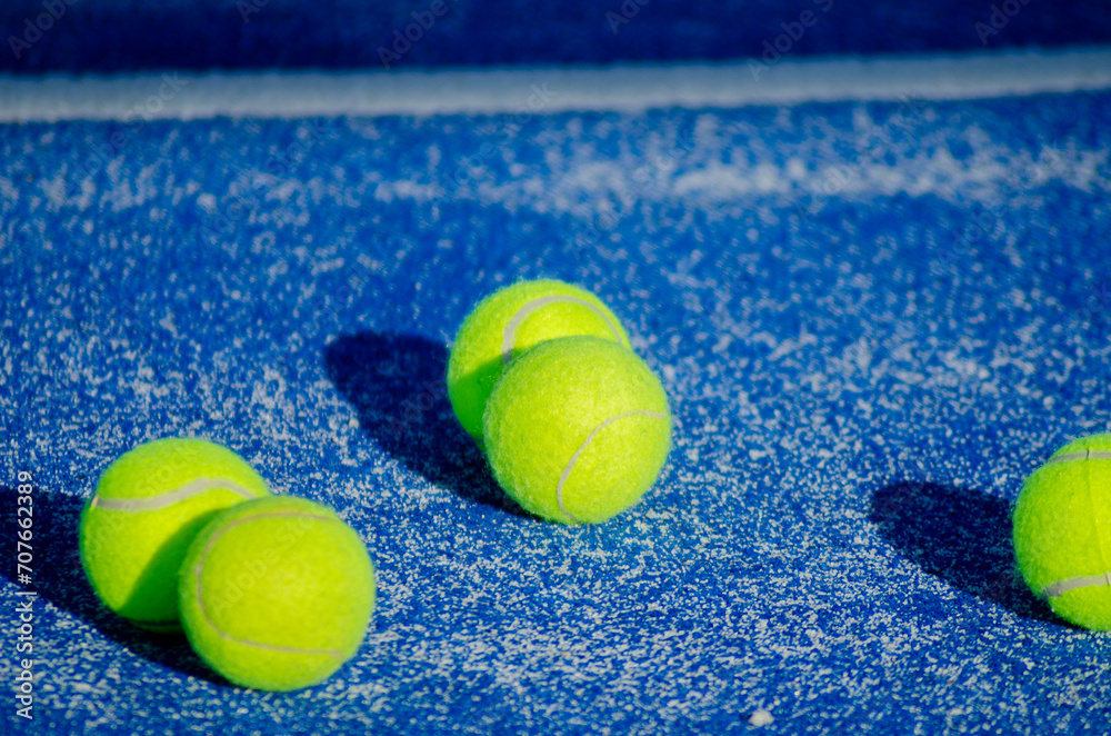 selective focus, balls on a blue paddle tennis court, racket sports concept