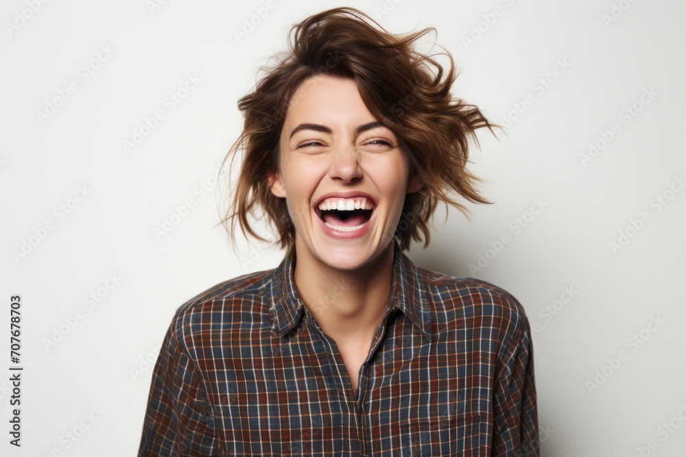 Portrait of a happy young woman laughing and looking at camera.