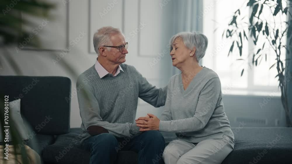 Senior sad couple has life problems. Husband supporting hugging wife. Old man calming woman cuddling stroking talking. Empathic male comforting consoling upset female with troubles. Family support.