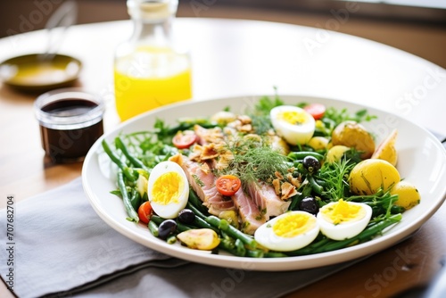 brightly lit nicoise salad with gleaming olive oil dressing drizzle