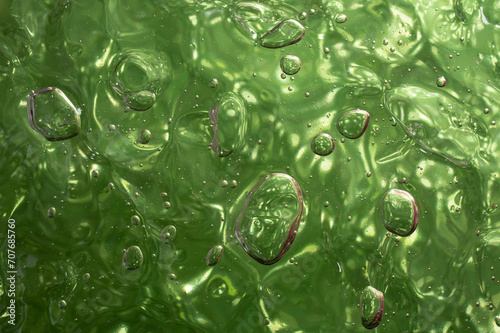 gel structure on green background, backdrop for cosmetic products, soft focus close up
