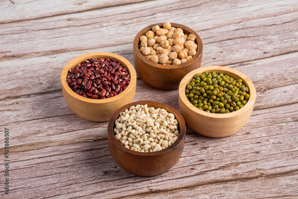 Mung beans, Red kidney beans, Chickpeas source and peeled barley in a basket wooden isolated on wood background Mung beans, Red kidney beans, Chickpeas source and peeled barley in a basket wooden isolated on wood background