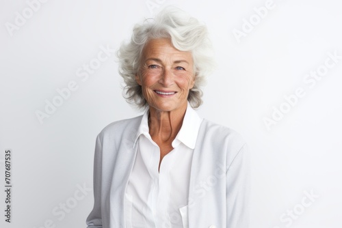 Portrait of smiling senior woman looking at camera over white background.