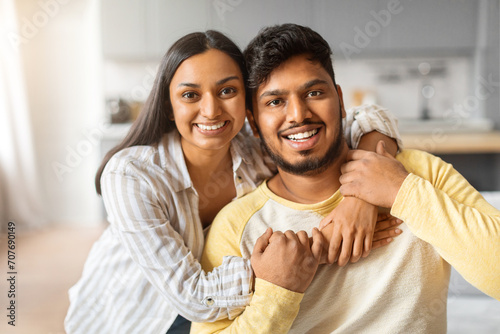 Portrait of joyful young indian couple embracing at home