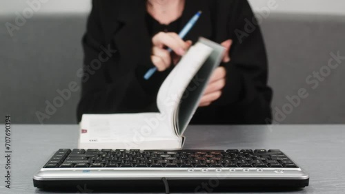 Work from home or study concept. Woman's hands using a keyboard and making additional notes in a notepad. Closing a deal or successful training. photo