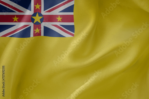 Niue waving flag close up fabric texture background photo