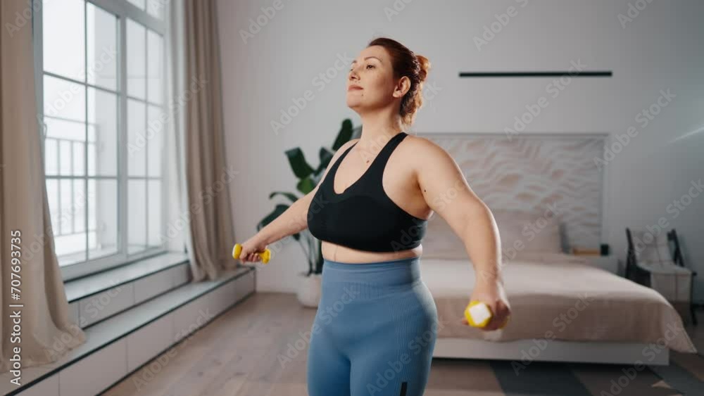 Woman doing fitness workout at home. Middle aged female training lifting dumbbells at home, exercising to keep herself in shape, to lose weight. Sport, healthy lifestyle, fitness workout concept. Woman doing fitness workout at home. Middle aged female training lifting dumbbells at home, exercising to keep herself in shape, to lose weight. Sport, healthy lifestyle, fitness workout concept.