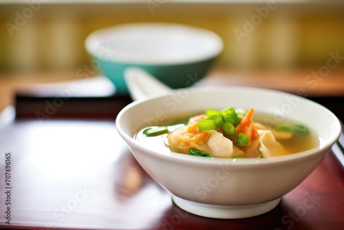 side view of wonton soup with focus on wontons