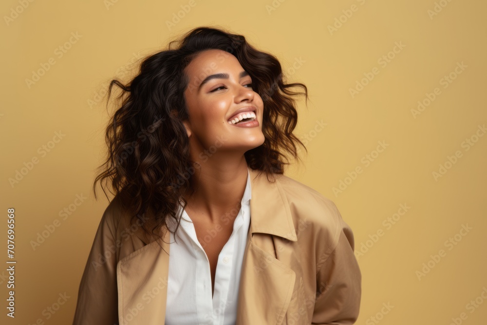 happy smiling african american woman in beige trench coat on yellow background