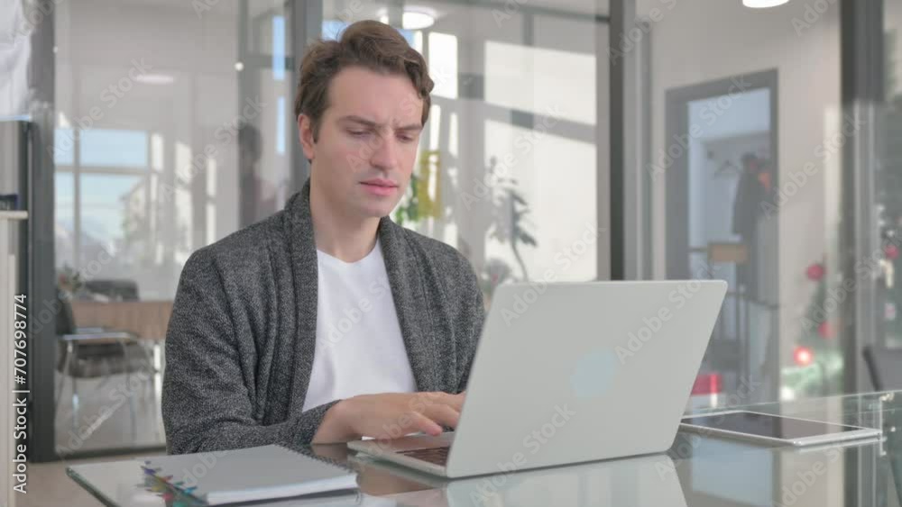Young Man Working on Laptop in Office Young Man Working on Laptop in Office