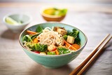 asian noodle bowl with chopsticks, vegetables, and tofu