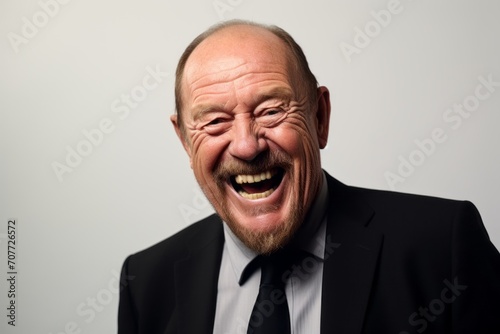 Elderly man with a happy expression in a suit and tie