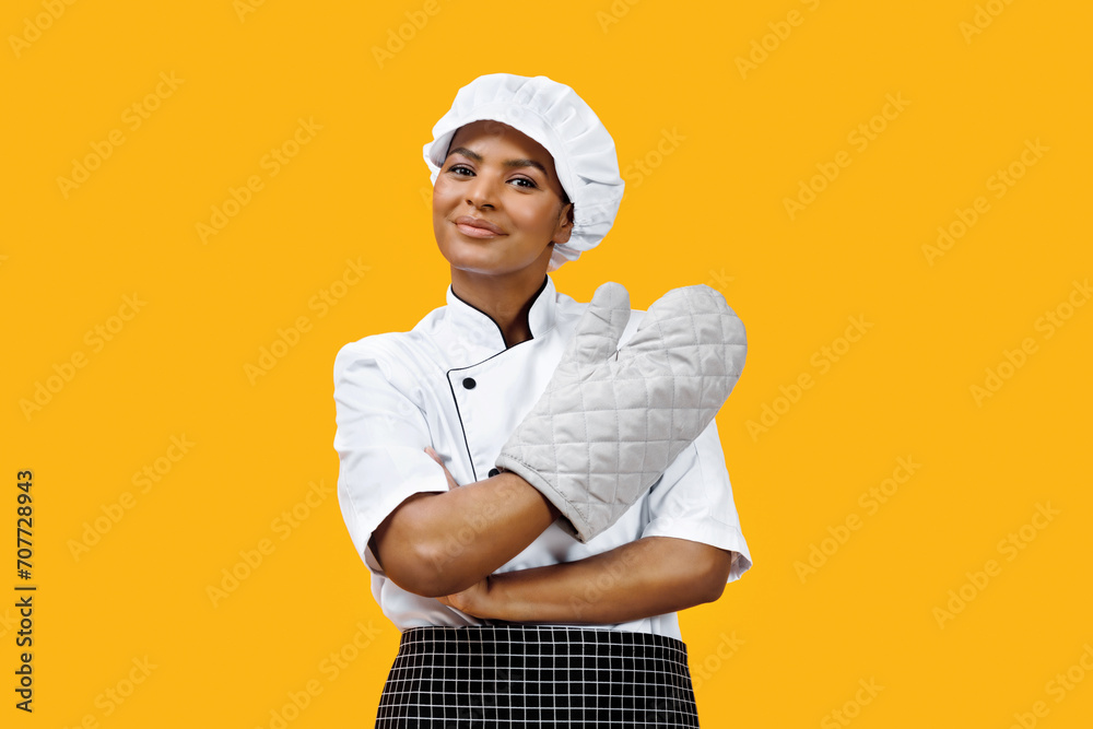 Εκτύπωση καμβά Confident black female chef with crossed arms wearing an oven mitt