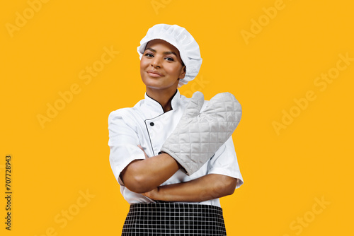 Confident black female chef with crossed arms wearing an oven mitt photo