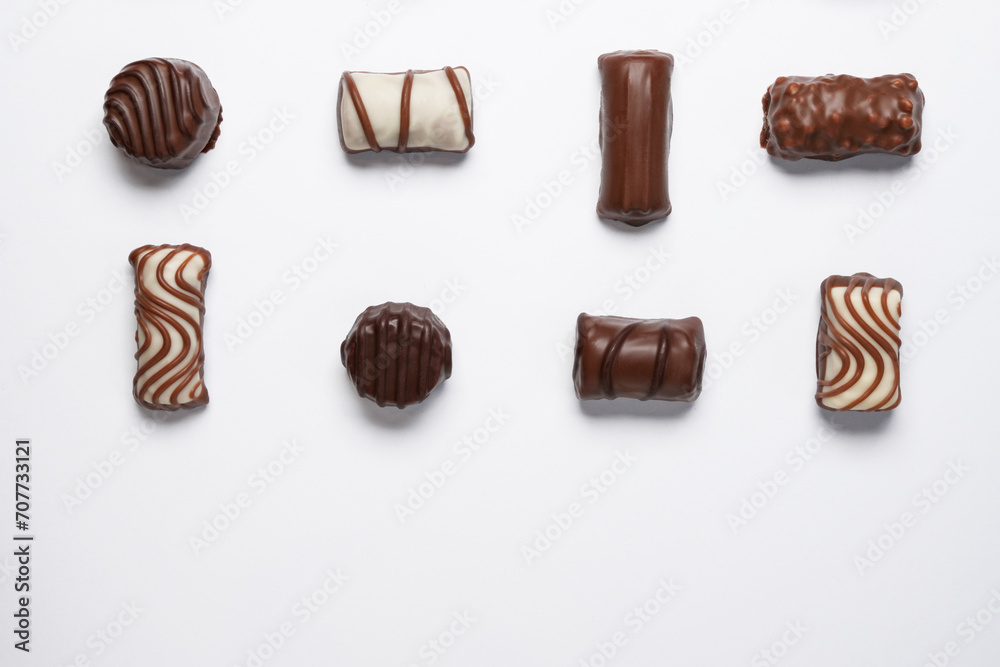 Flat lay of assortment of delicious chocolate candies isolated on white background. Flat lay, top view. Space for text. Flat lay of assortment of delicious chocolate candies isolated on white background. Flat lay, top view. Space for text.