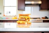 stack of grilled cheese sandwiches on a kitchen counter