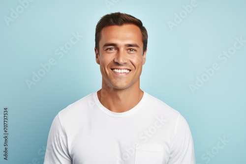 Portrait of handsome young man in white t-shirt on blue background