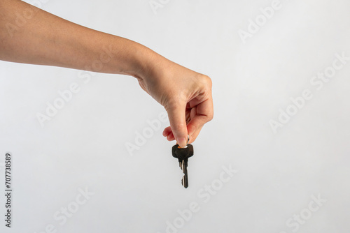 Key with a ring in hand on a white background.