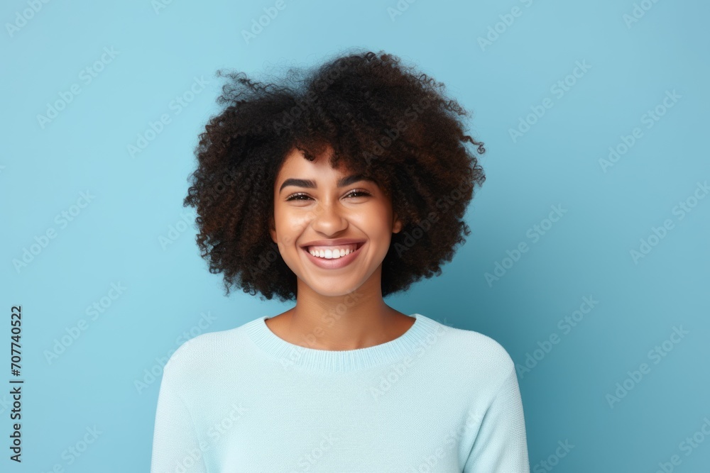 Happy african american woman with curly hair on blue background. Happy african american woman with curly hair on blue background.