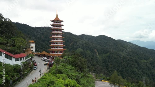 An aerial shot of the cable cars in the Genting Highlands area of Malaysia. The cable cars pass in front of the Chin Swee Temple, a buddhist pagoda with 10 floors.