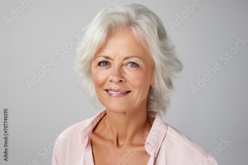 Portrait of happy senior woman looking at camera, over grey background