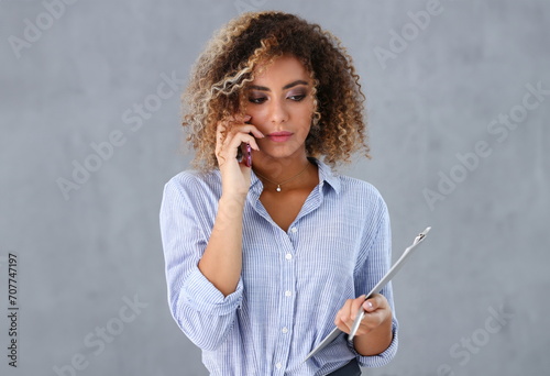 Beautiful black woman portrait. Holds a clipboard and talks on the phone fashion style curly hair with white locks eye view of the camera photo