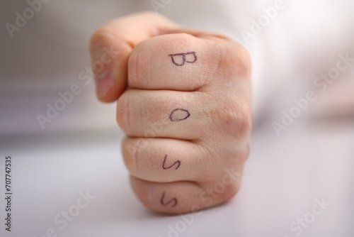 Male clenched fist in suit at office closeup. Aggressive career strategy angry negotiation strong riot solution for freedom victory leader decision boss tattoo control participation concept photo