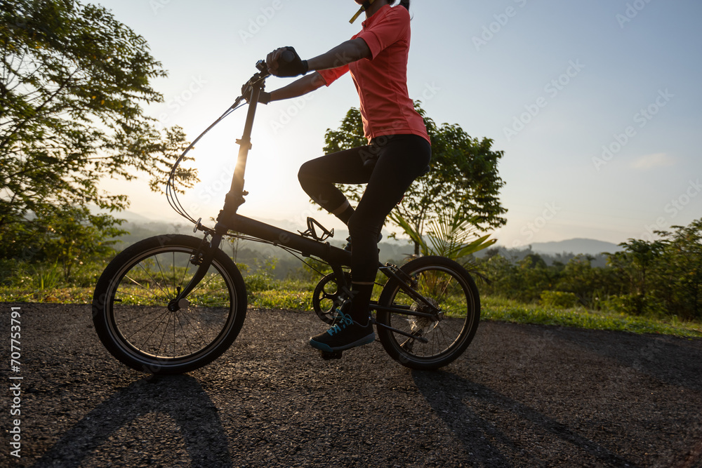 Riding folding bike on sunny mountain top road Riding folding bike on sunny mountain top road